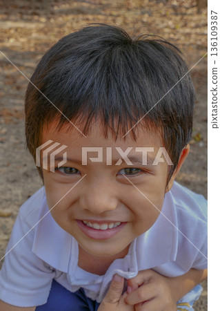 Closeup cute portrait of Asian little boy smiling outdoor Closeup cute portrait of Asian little boy smiling outdoor 136109387