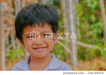 Closeup cute portrait of Asian little boy smiling outdoor Closeup cute portrait of Asian little boy smiling outdoor 136109419