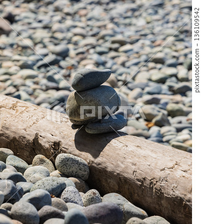 Pile of balanced round stones on the beach 136109542