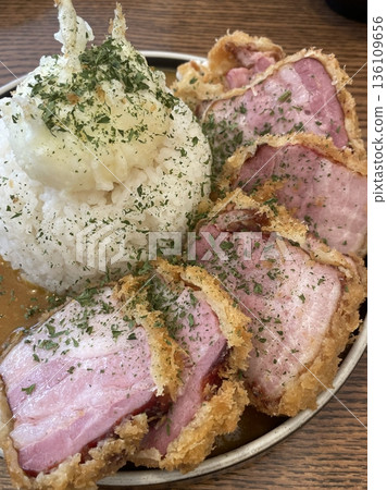 Crispy tonkatsu, a Japanese-style breaded and deep-fried pork cutlet, served with shredded cabbage and drizzled with savory sauce. A delightful balance of crunchy texture and juicy meat. Crispy tonkatsu, a Japanese-style breaded and deep-fried pork cutlet, served with shredded cabbage and drizzled with savory sauce. A delightful balance of crunchy texture and juicy meat. 136109656