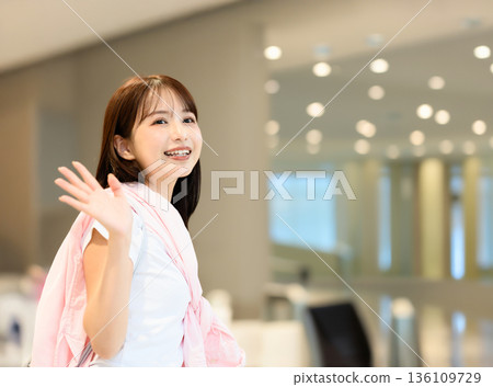 Woman waving hand at the airport 136109729