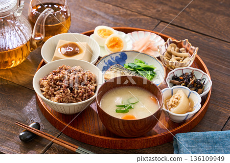 A Japanese breakfast with small dishes: mixed grain rice, miso soup, and grilled salted mackerel A Japanese breakfast with small dishes: mixed grain rice, miso soup, and grilled salted mackerel 136109949