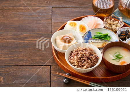A Japanese breakfast with small dishes: mixed grain rice, miso soup, and grilled salted mackerel A Japanese breakfast with small dishes: mixed grain rice, miso soup, and grilled salted mackerel 136109951