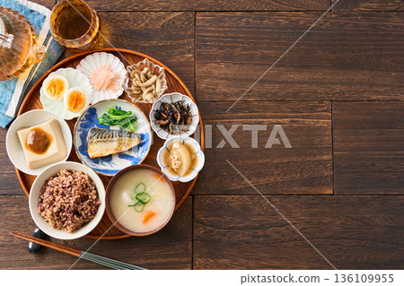 A Japanese breakfast with small dishes: mixed grain rice, miso soup, and grilled salted mackerel A Japanese breakfast with small dishes: mixed grain rice, miso soup, and grilled salted mackerel 136109955