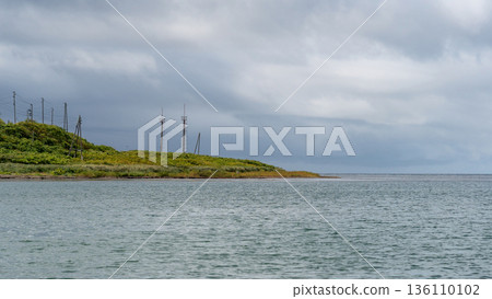 Calm sea with cloudy sky and coastline 136110102