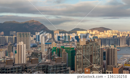 Warm Evening Light Illuminates Hung Hom Skyline Beside Harbour 136110258