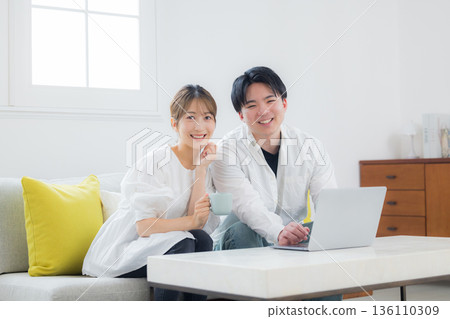 看著一台個人計算機的年輕夫婦 136110309