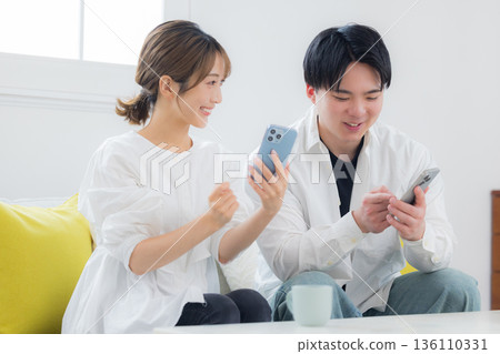 A young couple looking at a smartphone A young couple looking at a smartphone 136110331