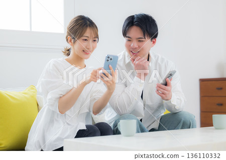 A young couple looking at a smartphone A young couple looking at a smartphone 136110332