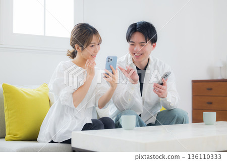 A young couple looking at a smartphone A young couple looking at a smartphone 136110333