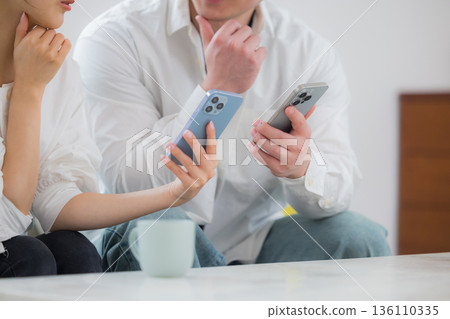 A young couple looking at a smartphone A young couple looking at a smartphone 136110335