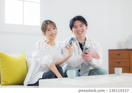A young couple looking at a smartphone A young couple looking at a smartphone 136110337