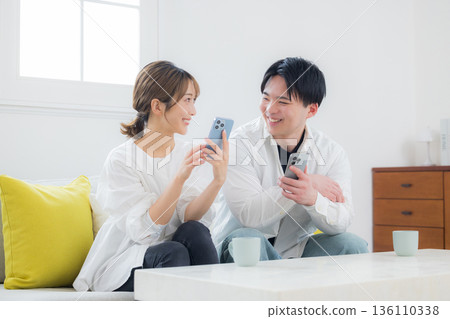 A young couple looking at a smartphone 136110338