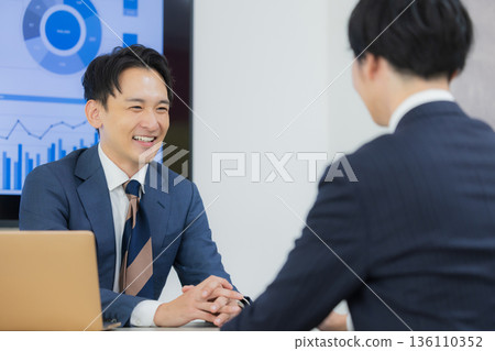 一位商人在辦公室會議 一位商人在辦公室會議 136110352