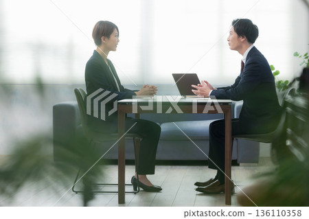 一位商人在辦公室會議 一位商人在辦公室會議 136110358