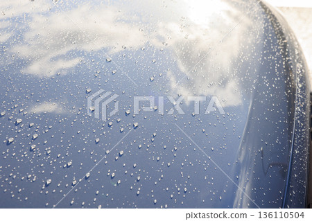 Countless shining droplets and reflections on the hood after the rain 136110504