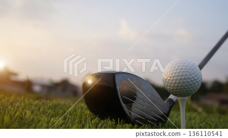 Golf clubs and balls on a green lawn in a beautiful golf course with morning sunshine. 136110541