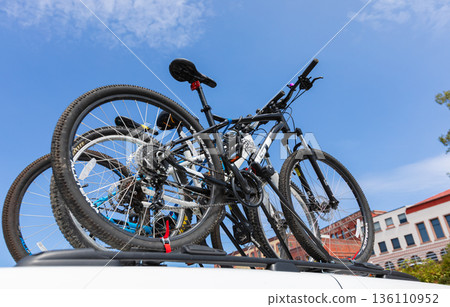 Bicycles on the rack on top of the car with bicycles. Bicycles on the rack on top of the car with bicycles. 136110952