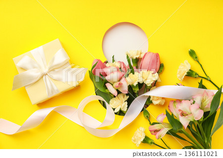 Colorful flowers and a gift box on a bright background Colorful flowers and a gift box on a bright background 136111021