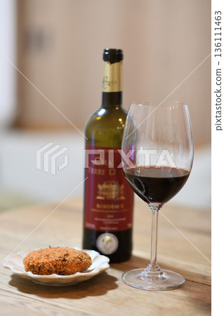 Red wine and wine glasses on a dining table with croquettes Red wine and wine glasses on a dining table with croquettes 136111463