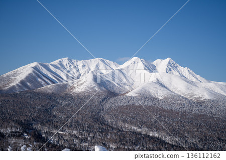 冬日北海道壯麗的雪山景色,舍利山在藍天和銀色山脊的映襯下熠熠生輝。 冬日北海道壯麗的雪山景色,舍利山在藍天和銀色山脊的映襯下熠熠生輝。 136112162