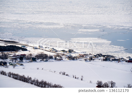 一張展現冬季北海道東部寧靜的陸地和天空景色的照片，俯瞰著被浮冰覆蓋的鄂霍次克海。 136112170