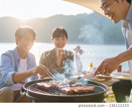 一家人在水邊露營，享受燒烤。 136112233