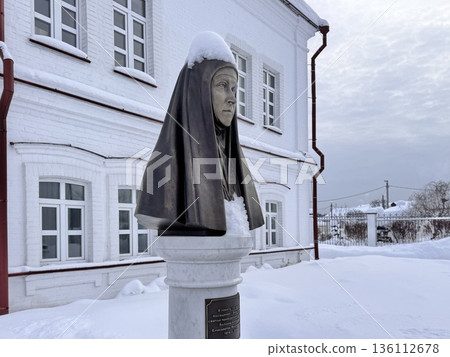 A young, happy blonde girl is traveling in winter, sitting on a train, looking out the window and drinking hot tea A young, happy blonde girl is traveling in winter, sitting on a train, looking out the window and drinking hot tea 136112678