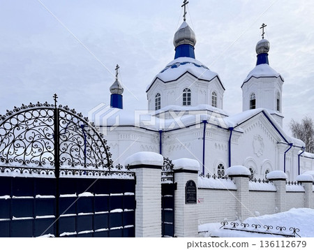 A young, happy blonde girl is traveling in winter, sitting on a train, looking out the window and drinking hot tea 136112679