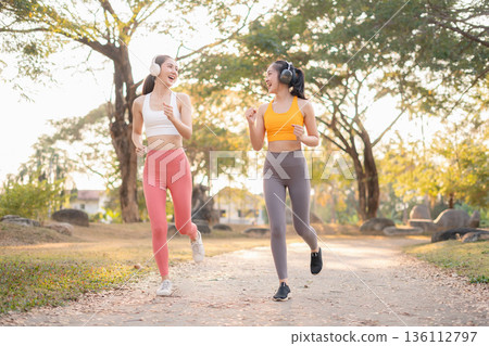 Two fit woman using smartphone playing social media after yoga training. lifestyles and healthcare. Two fit woman using smartphone playing social media after yoga training. lifestyles and healthcare. 136112797
