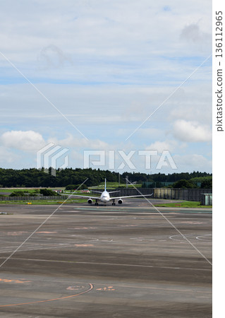 Front view of an airplane moving down the runway at Narita Airport 136112965