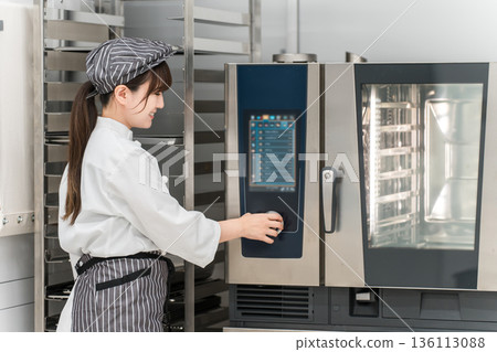 女廚師操作商用烤箱 女廚師操作商用烤箱 136113088