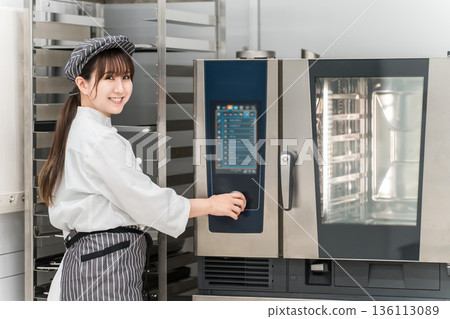 女廚師操作商用烤箱 女廚師操作商用烤箱 136113089