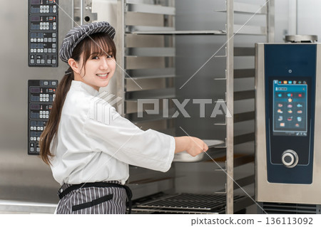 女廚師操作商用烤箱 女廚師操作商用烤箱 136113092