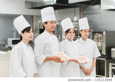 Chefs, cooks, and cooks in chef coats holding chicken 136113094