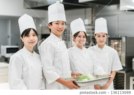 Chefs, cooks, and cooks in cook coats holding vegetables 136113099