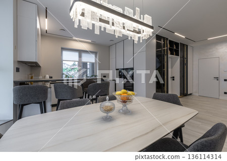 Luxurious open plan dining and kitchen area with designer lighting Luxurious open plan dining and kitchen area with designer lighting 136114314