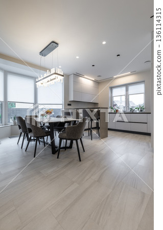 Modern open-plan kitchen and dining area with elegant lighting 136114315