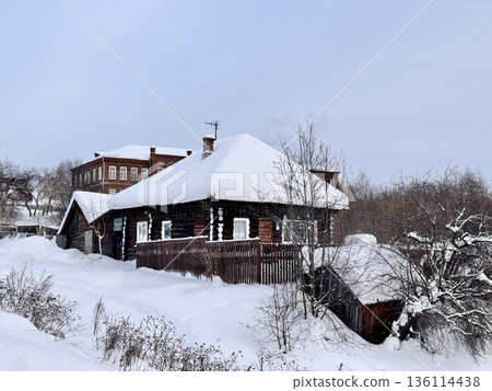 traditional Russian log cabin with carved architraves in winter in the village 136114438
