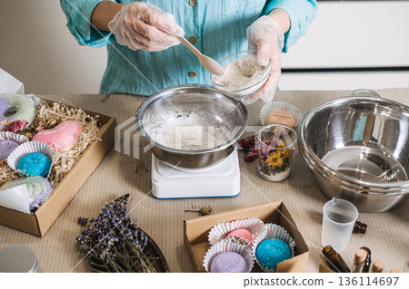 Metal bowl on digital scale holds powdered ingredients near dried lavender and glass jars. Raw cosmetic ingredients, botanical textures, herbal skincare diy. 136114697