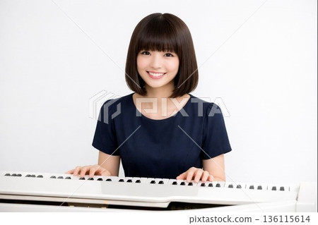 A woman with a bob haircut playing the grand piano in front of a white wall 2 136115614