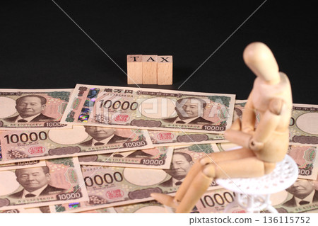10,000 yen bill, TAX letter block, and wooden doll (tax, tax return image) 10,000 yen bill, TAX letter block, and wooden doll (tax, tax return image) 136115752