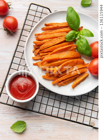 Sweet potato fries with ketchup and fresh basil 136115944