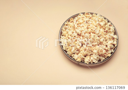 Popcorn on plate on beige background. Space for text Popcorn on plate on beige background. Space for text 136117069