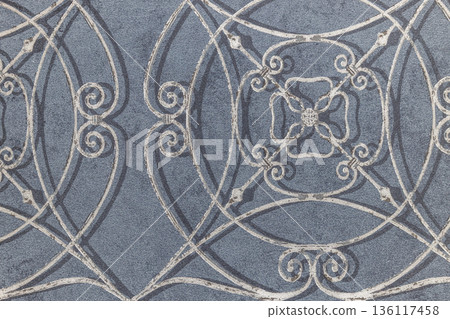 Ornate wrought iron pattern on blue wallcovering background 136117458