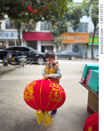 Child Joyfully Holding A Big Red Lantern During Festive Lunar New Year Preparations Child Joyfully Holding A Big Red Lantern During Festive Lunar New Year Preparations 136119313