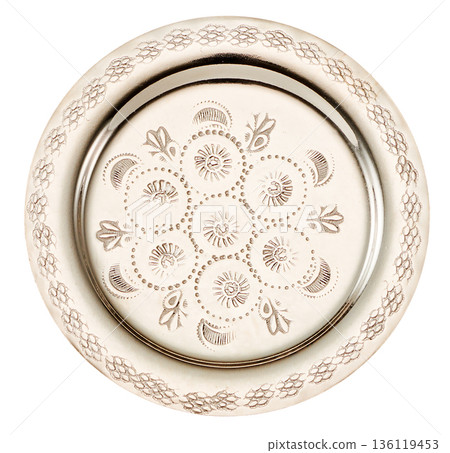 A round silver coaster with Moroccan-style carvings cut out on a white background A round silver coaster with Moroccan-style carvings cut out on a white background 136119453