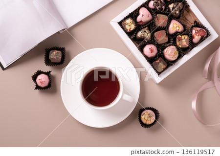 Chocolate sweets with cup of tea in cozy flat lay composition 136119517