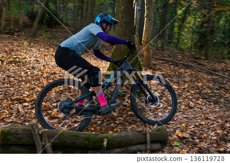 Mountain Biker Rides Through Autumn Forest Trail in Action Packed Outdoor Adventure Mountain Biker Rides Through Autumn Forest Trail in Action Packed Outdoor Adventure 136119728
