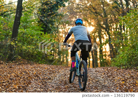 Mountain Biker On Forest Trail In Autumn Light Wearing Helmet And Bright Socks Mountain Biker On Forest Trail In Autumn Light Wearing Helmet And Bright Socks 136119790
